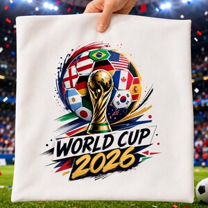 May include: A white square pillowcase featuring a graphic of a soccer ball composed of various national flags, a gold-colored trophy in the center, and the bold black and yellow text "WORLD CUP 2026" printed across the lower portion of the design.