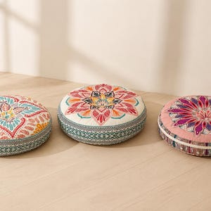 May include: Three round floor cushions featuring intricate, colorful mandala-style patterns. The left cushion has teal and yellow accents, the center has red and orange, and the right has a deep pink and purple design with patterned side borders.