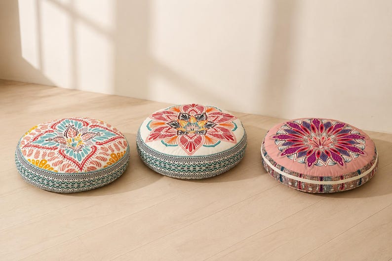 May include: Three round floor cushions featuring intricate, colorful mandala-style patterns. The left cushion has teal and yellow accents, the center has red and orange, and the right has a deep pink and purple design with patterned side borders.