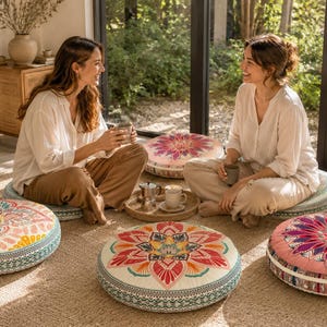 May include: Four round floor cushions featuring intricate mandala-inspired patterns in vibrant shades of pink, orange, teal, and cream. Each cushion has a low-profile design with a decorative side border and a flat, circular top surface.