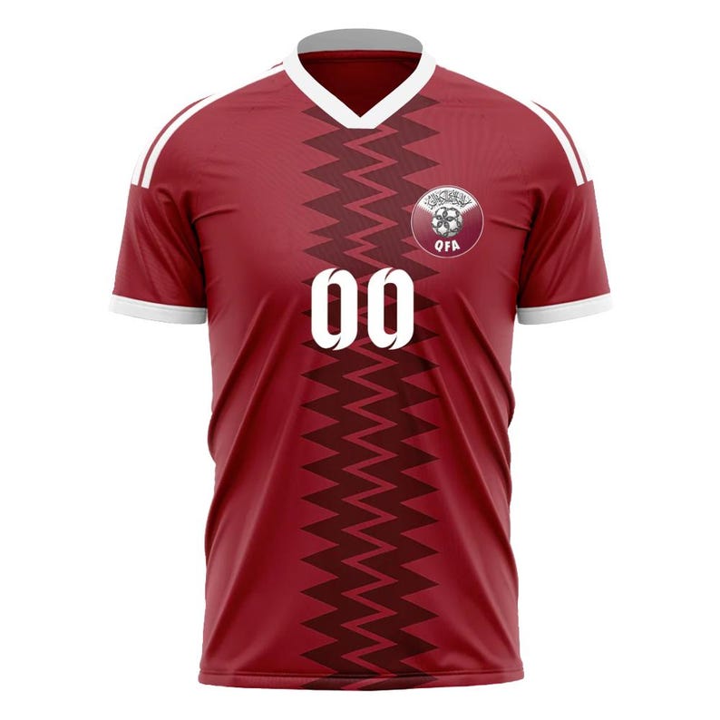 Puede incluir: Camiseta de f&uacute;tbol granate con detalles blancos, que presenta un dise&ntilde;o en zigzag en la parte delantera. La camiseta tiene el n&uacute;mero "00" en blanco y un emblema circular en el pecho. Las mangas tienen rayas blancas.