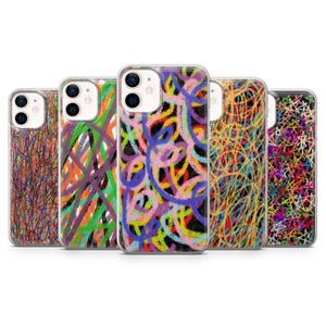 Pode incluir: Uma coleção de cinco capas de telemóvel com designs abstratos coloridos. As capas apresentam padrões rabiscados em várias cores, incluindo vermelho, laranja, verde, roxo e amarelo, sobre um fundo preto. As capas são feitas de plástico transparente.