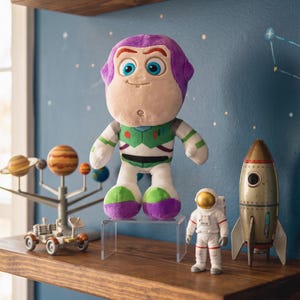 May include: A soft Buzz Lightyear toy, with a purple hood and green and white spacesuit, is displayed on a clear acrylic stand. A toy astronaut, a rocket, and a solar system model are also on the wooden shelf. The background is a blue wall with star decals.
