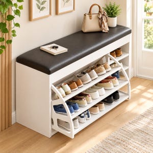 May include: A white shoe storage bench with a black padded seat, featuring multiple open shelves filled with various pairs of casual shoes. A beige handbag with a patterned scarf and a small notebook with keys sit on top of the bench.