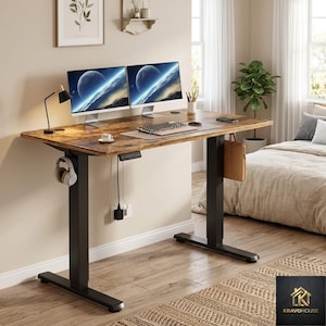 May include: A brown and black adjustable standing desk with two computer monitors displaying a space scene. The desk has a keyboard, mouse, and a pair of headphones. A brown leather bag hangs from the side. The desk is in a home office setting.