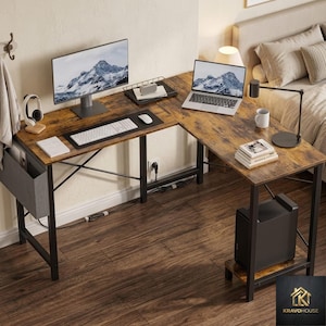 May include: L-shaped desk with a distressed wood finish and black metal frame. The desk features a computer monitor, laptop, keyboard, mouse, and a small organizer. A computer tower sits on a lower shelf. The desk is in a home office setting.
