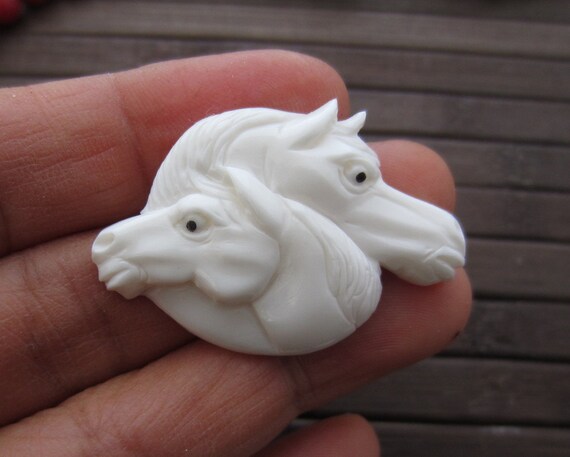 精巧に彫刻された2頭の馬の頭、バッファローの骨の彫刻、牛