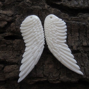 Puede incluir: Dos alas de &aacute;ngel talladas en blanco con patrones de plumas detallados. Las alas est&aacute;n hechas de un material blanco liso y son perfectas para proyectos de artesan&iacute;a.