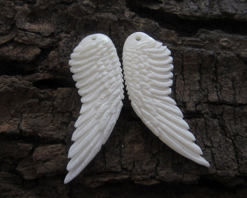 Puede incluir: Dos alas de &aacute;ngel talladas en blanco con patrones de plumas detallados. Las alas est&aacute;n hechas de un material blanco liso y son perfectas para proyectos de artesan&iacute;a.