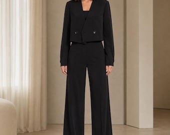 Completo da donna a due pezzi, composto da blazer corto con scollo a V e pantaloni a gamba larga a vita alta, abbigliamento da ufficio minimalista.