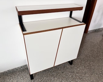 Moderne, handgemaakte meubels met strakke lijnen en een contrast tussen wit en walnoot.