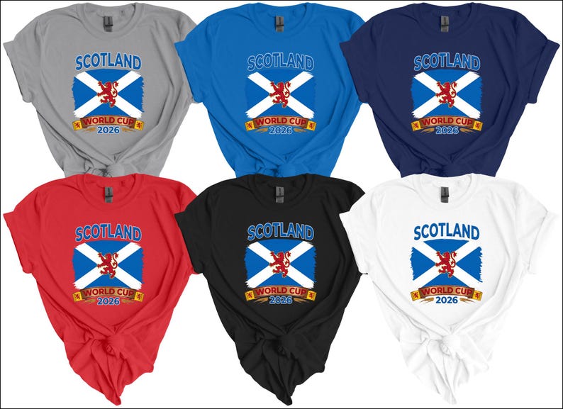May include: Six t-shirts in various colors: gray, blue, navy, red, black, and white. Each shirt features the word "SCOTLAND" above a design of the Scottish flag and the text "WORLD CUP 2026".
