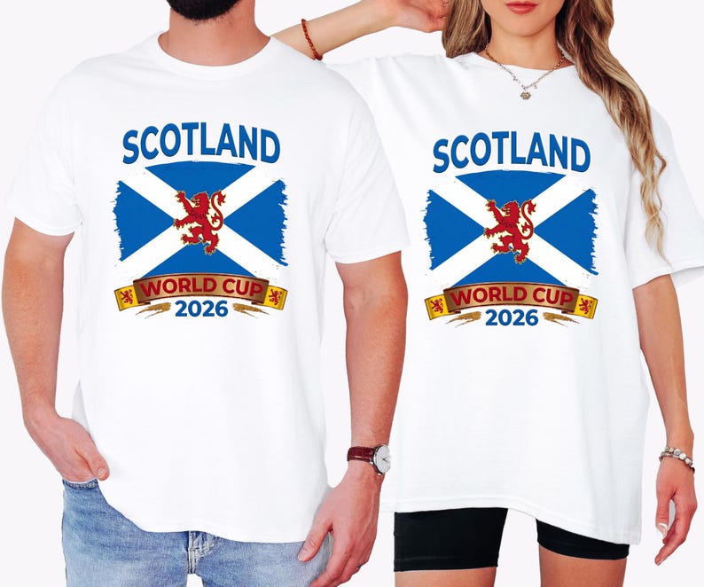 May include: White t-shirts with a graphic featuring the Scottish flag, a red lion, and the text "SCOTLAND WORLD CUP 2026" in blue and gold. The design is centered on the front of the shirts, suitable for sports fans.