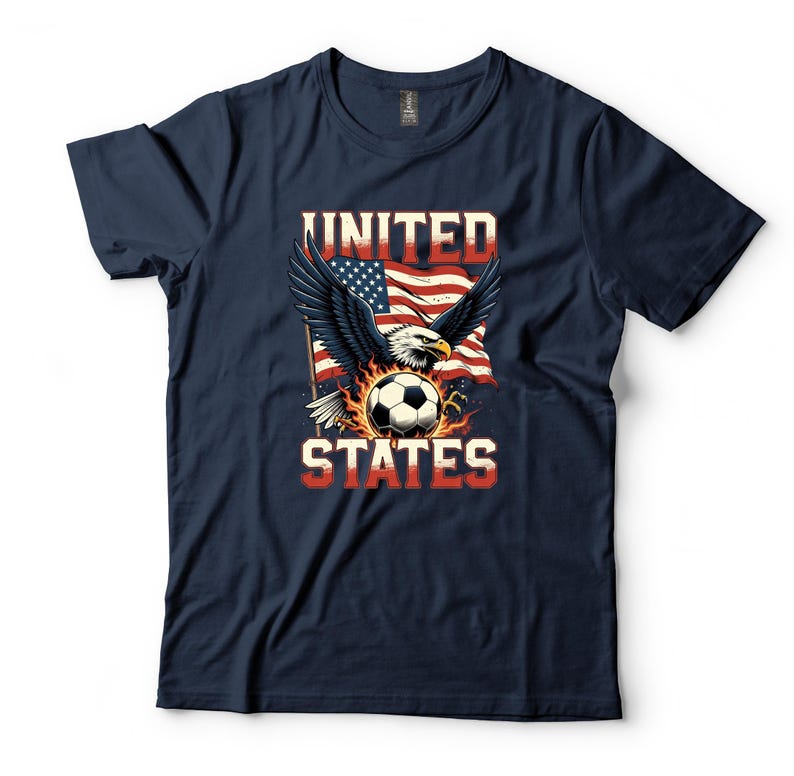 K&ouml;nnte beinhalten: Ein marineblaues Kurzarm-T-Shirt mit einem Grafikdruck eines Wei&szlig;kopfseeadlers mit ausgebreiteten Fl&uuml;geln, einem Fu&szlig;ball und einer amerikanischen Flagge. Der Text UNITED STATES ist in einer fetten, abgenutzten Schriftart aufgedruckt.