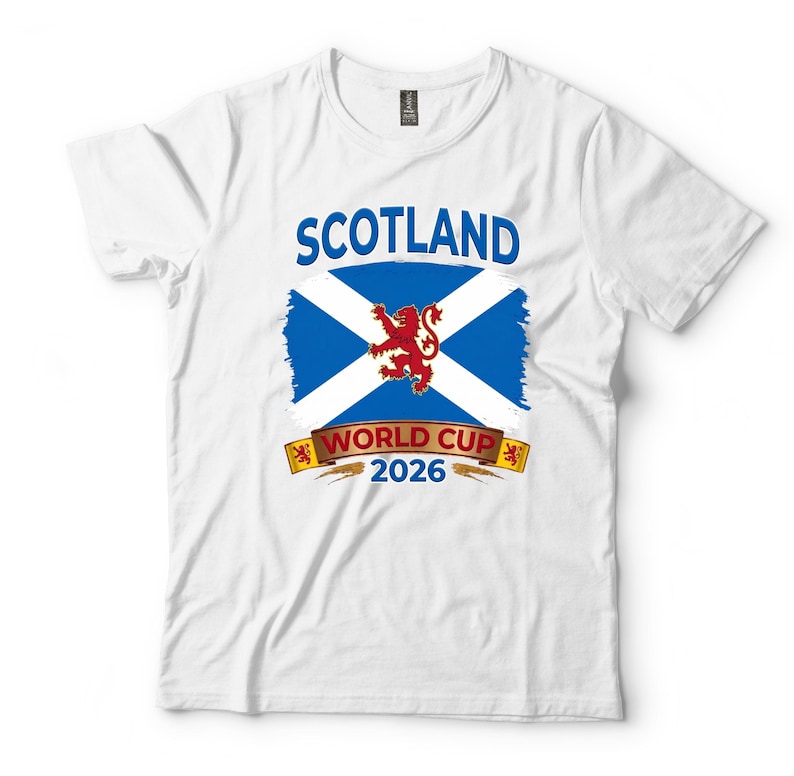 May include: White t-shirt featuring a graphic design for Scotland's World Cup 2026. The design includes the word "SCOTLAND" in blue, a blue and white flag, a red lion, and the text "WORLD CUP 2026".