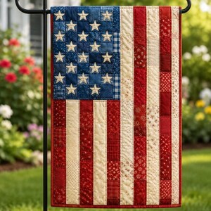 May include: A rectangular garden flag featuring a patchwork design of the American flag. The blue canton contains white appliqued stars, while the stripes are composed of various red and cream fabric squares with diverse small-scale patterns.