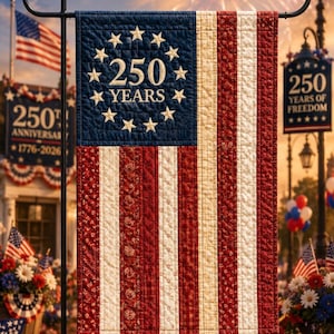May include: A rectangular garden flag featuring a quilted design with red and cream vertical stripes. The blue canton displays a circle of thirteen white stars surrounding the text 250 YEARS in white lettering, suspended from a black metal stand.