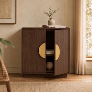 Peut inclure: Une armoire en bois brun foncé avec deux portes dotées de grandes poignées en métal doré en forme de demi-cercle. Le meuble présente une structure rectangulaire, un dessus plat et une étagère intérieure visible par la porte droite entrouverte.