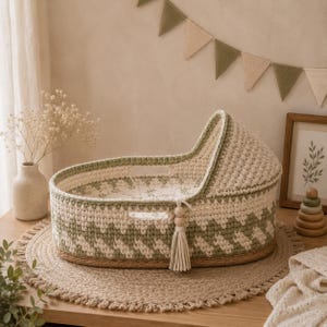 Può includere: Una culla per neonati all'uncinetto fatta a mano in crema e verde salvia, con un motivo a zig-zag. La culla ha un nappa e un interno a fantasia floreale. Poggia su un tappeto rotondo intrecciato, creando un'estetica accogliente. Misura circa 70 cm di lunghezza.