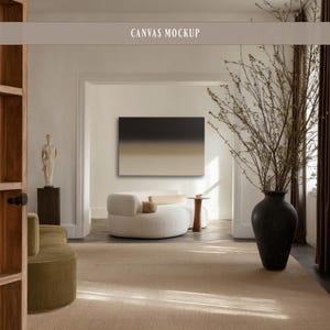 May include: A rectangular canvas mockup featuring an abstract gradient design that transitions from a dark charcoal top to a light beige bottom, displayed on a wall above a curved white sofa in a room with a large black vase and a statue.