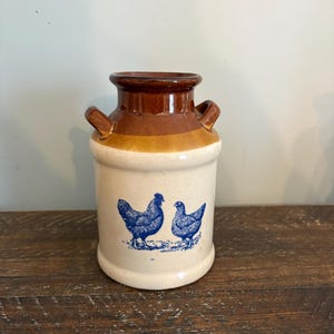 May include: A white ceramic mug with a black handle and the text "But First, Coffee" in a handwritten style. The mug is on a white surface. The mug is 4 inches tall.