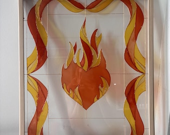 May include: A rectangular framed glass panel featuring a central orange heart shape surrounded by stylized yellow and orange flames. The border consists of flowing, ribbon-like orange and yellow patterns outlined in thin metallic lines.