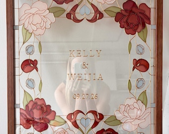 May include: A rectangular stained glass panel in a wooden frame featuring a floral border of red and pale pink roses with green leaves. The center of the glass displays the text KELLY & WEIJIA and the date 09.27.26 in a gold-colored font.