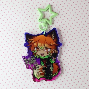 May include: A colorful anime-style keychain featuring a fox-like character with orange hair and green accents. The character is wearing a black outfit with green details and the text "RAWR XD". The keychain has a green star-shaped clip.