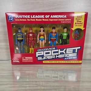 May include: A Justice League of America DC Comics Pocket Super Heroes JLA box set featuring plastic action figures of Batman, The Flash, Wonder Woman, Superman, Green Lantern, and a bonus Atom figure in a red, yellow, and blue display package.
