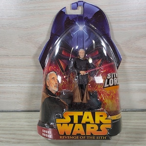 Peut inclure: Une figurine articulée Star Wars Revenge of the Sith représentant le Comte Dooku dans son emballage blister d'origine. La carte présente un portrait du Comte Dooku, le texte Sith Lord et le logo Star Wars. La figurine porte une tunique sombre.