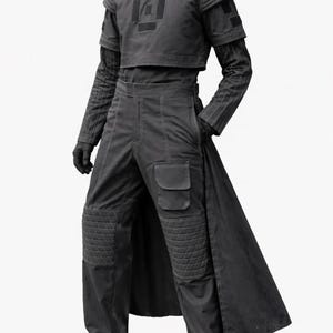 May include: A dark gray futuristic outfit. The ensemble includes a cropped top with a square design, long-sleeved shirt, high-waisted pants with pockets, and a long coat. The pants have quilted knee pads. The outfit is completed with gloves and shoes.