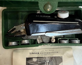 May include: A black Singer buttonholer attachment with a white dial, housed in a green plastic storage case with several metal cams. Included is a paper instruction sheet titled Instructions For Using SINGER BUTTONHOLER NO. 160506 Form 20409 (9-51).