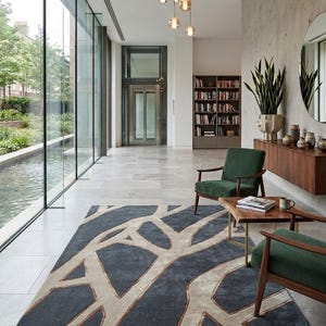May include: A modern living room with a large, dark gray rug featuring a beige tree branch design. Two green armchairs with wooden frames and a small wooden table are in front of the rug. A large window and a decorative light fixture are also visible.