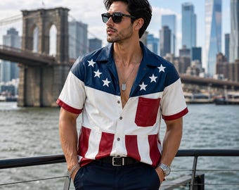 May include: A short-sleeved button-down shirt featuring a red, white, and blue design inspired by the American flag. The upper section is blue with white stars, while the lower portion displays red and white vertical stripes. It includes a chest pocket.