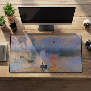 Könnte beinhalten: Ein rechteckiges Mauspad mit einem Landschaftsgemälde einer Hafenszene mit Booten, einer roten Sonne und Reflexionen auf dem Wasser. Das Mauspad liegt auf einem Holztisch mit einem Computermonitor, Pflanzen und anderem Bürozubehör.