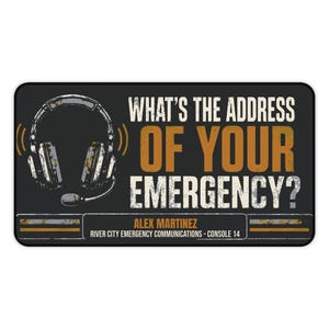 May include: A rectangular black sign featuring a graphic of a headset on the left. The text reads: WHAT'S THE ADDRESS OF YOUR EMERGENCY? ALEX MARTINEZ RIVER CITY EMERGENCY COMMUNICATIONS - CONSOLE 14. The design has a distressed, weathered texture.