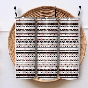 May include: Three cylindrical tumblers with black straws, featuring a repeating pattern of horizontal black lines, geometric shapes, and wavy lines over a soft pink background with faint floral outlines. The design is consistent across all three items.