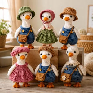 Op de afbeelding: Zes gehaakte ganzenpoppen met witte lichamen en oranje snavels. Ze dragen diverse outfits, waaronder blauwe tuinbroeken met bruine schoudertassen, een groene jurk, een roze jurk en hoeden in de kleuren groen, roze, bruin en beige.