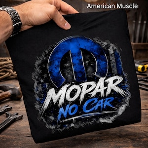 May include: A black t-shirt featuring a blue Mopar logo graphic with a distressed American flag pattern. The text "MOPAR" appears in white, and "NO CAR" is printed in blue below it. The design has a textured, weathered appearance.