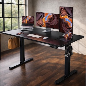 May include: A black adjustable standing desk with multiple computer monitors, a laptop, and a tablet. A brown leather handbag hangs from the side. A wireless keyboard, mouse, and headphones are also visible.