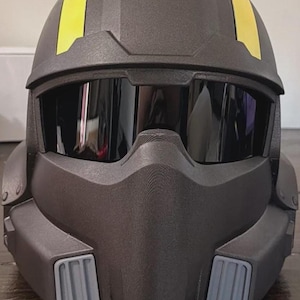 May include: A matte black full-face helmet featuring a dark tinted visor, two bright yellow vertical stripes running across the top, and two light gray rectangular vents positioned on the lower front section of the chin guard.