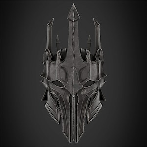 May include: A dark metallic helmet featuring a tall, pointed central crest and multiple sharp, upward-facing spikes. The surface has a weathered, gunmetal grey finish with visible ridges, angular geometric cutouts, and a structured, armoured appearance.