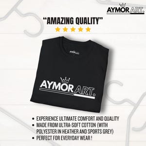 May include: A black short-sleeved t-shirt featuring the white text AYMOR ART. with a crown icon above the letters. The shirt is displayed flat with a round neckline and a brand label on the inside collar. The design includes a horizontal line.