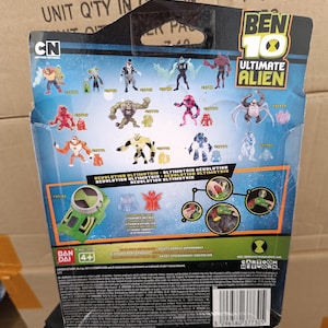 以下が含まれることがあります： ベン10アルティメットエイリアンの玩具パッケージの裏面。パッケージには、さまざまなアクションフィギュアと「Ben 10 Ultimate Alien」の文字が描かれています。Cartoon NetworkのロゴとBandaiのロゴも含まれています。