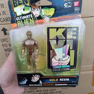 May include: A packaged "Ben 10 Ultimate Alien" action figure, featuring a gold-colored Kevin figure. The packaging includes the "Ben 10" logo, "Ultimate Alien" text, and "Limited Edition GOLD" text. The carton size is 49.3x40.7x21.9 cm.