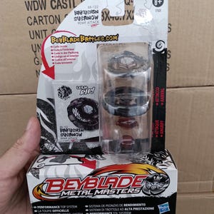 Peut inclure: Une toupie Beyblade Metal Masters Bakushin Susanow 90WF Attack dans son emballage blister d'origine. L'ensemble comprend une toupie noire et argentée, un composant de lancement et une carte de collection avec le texte Let it Rip!