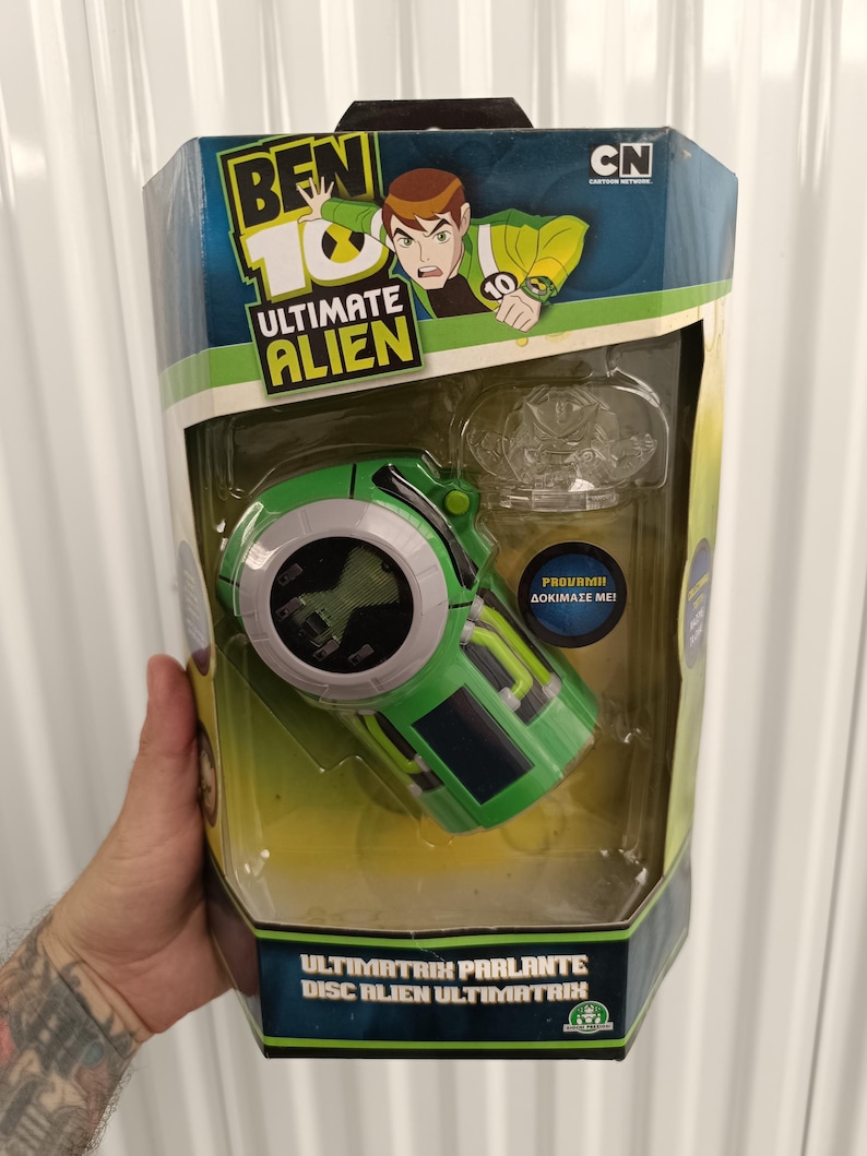 Pode incluir: Um brinquedo verde e preto Ben 10 Ultimate Alien na embalagem original. O brinquedo &eacute; um dispositivo em forma de disco com um visor digital. A embalagem apresenta o logotipo Ben 10 e ilustra&ccedil;&otilde;es de personagens. O texto na embalagem diz "ULTIMATRIX PARLANTE DISC ALIEN ULTIMATRIX".