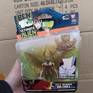 May include: A "Ben 10 Ultimate Alien" action figure in a clear plastic package. The figure is gold-colored with green accents and has large wings. The packaging includes the "Ben 10 Ultimate Alien" logo and the text "Limited Edition GOLD".