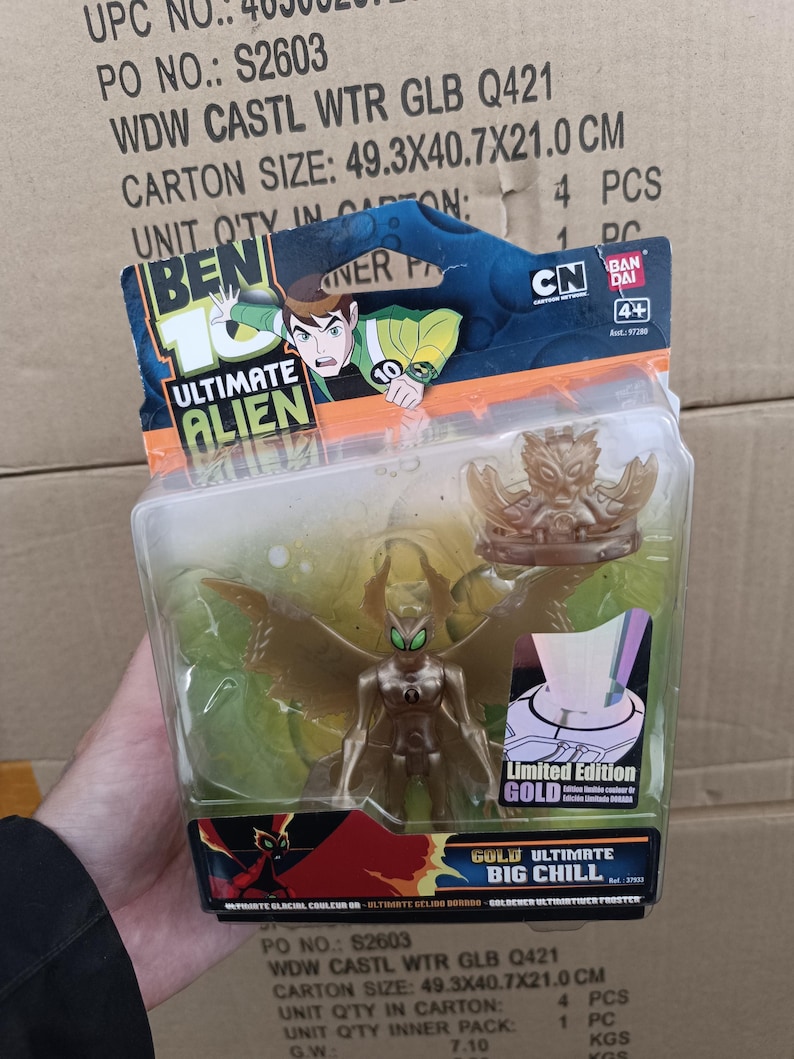 May include: A "Ben 10 Ultimate Alien" action figure in a clear plastic package. The figure is gold-colored with green accents and has large wings. The packaging includes the "Ben 10 Ultimate Alien" logo and the text "Limited Edition GOLD".