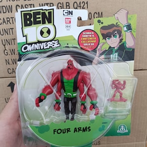 May include: A Ben 10 Omniverse action figure of Four Arms, a red and green character with four arms, in a clear plastic package. The package also includes a small red figure. The packaging features the Ben 10 logo and the text "FOUR ARMS".